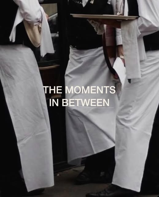 Waiters in white aprons between courses